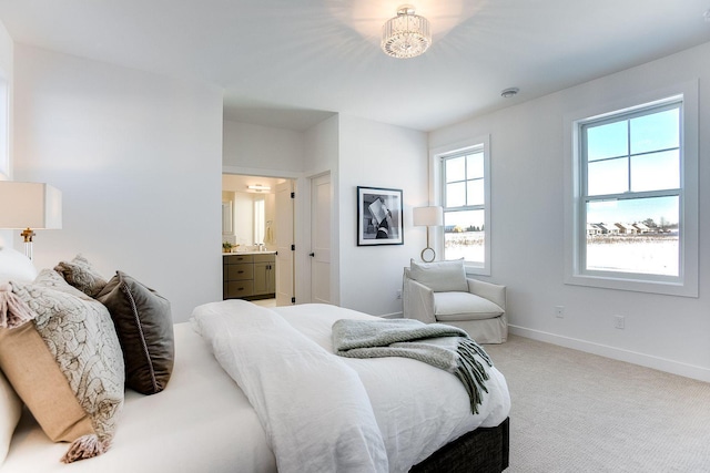 carpeted bedroom with multiple windows, ensuite bathroom, and a notable chandelier