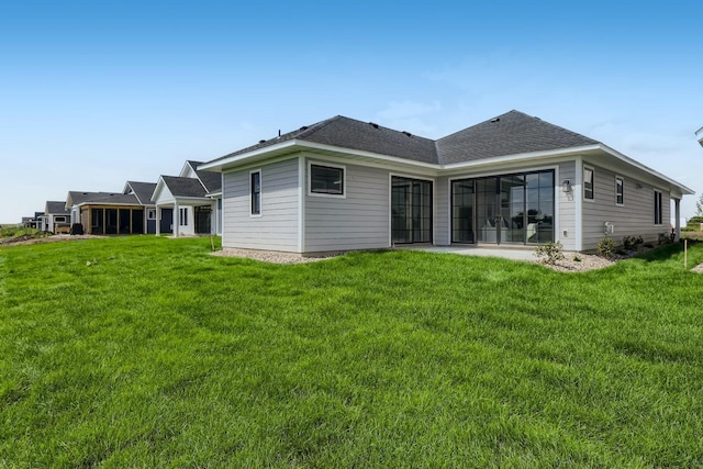 rear view of property with a lawn