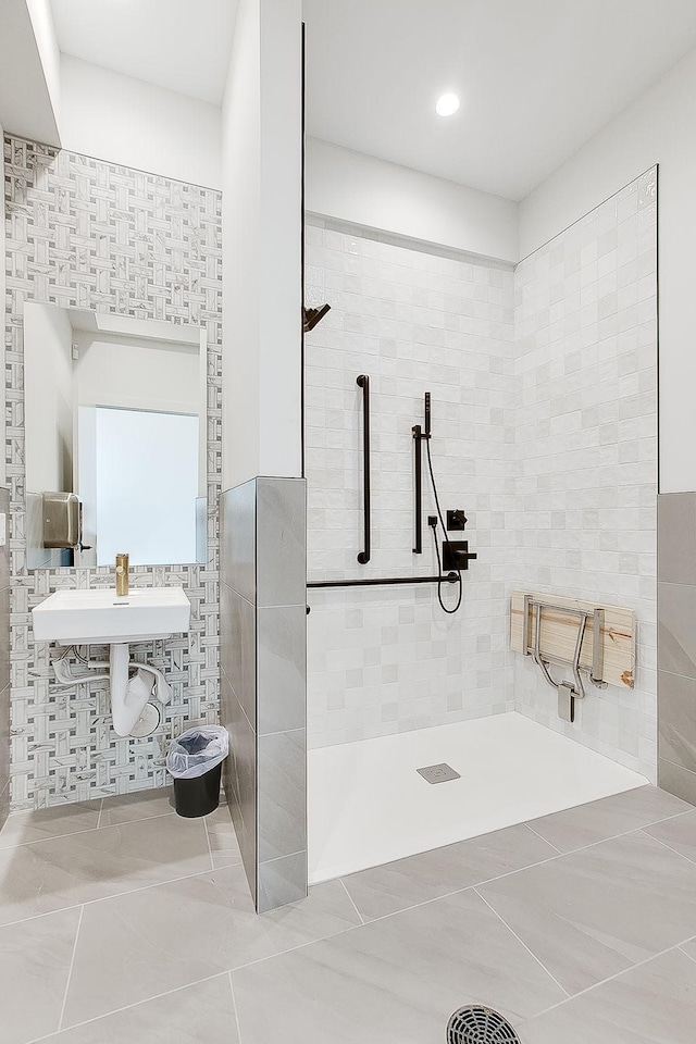 bathroom with a tile shower, tile patterned floors, and tile walls