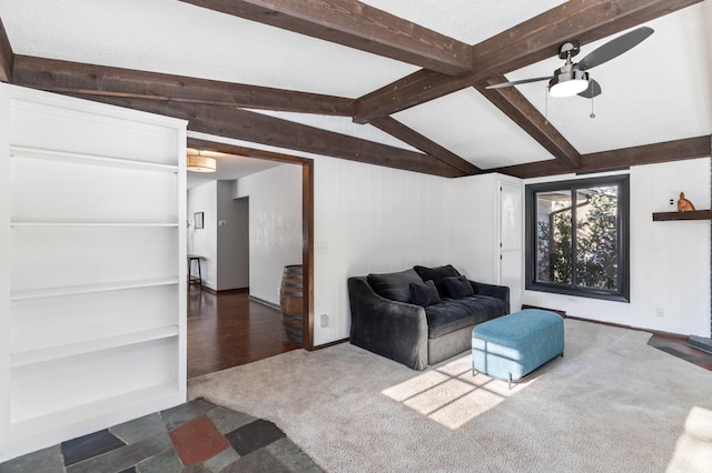 living room featuring ceiling fan, vaulted ceiling with beams, and dark colored carpet