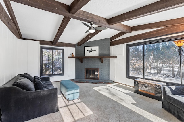 carpeted living room featuring a fireplace, wood walls, ceiling fan, and lofted ceiling with beams