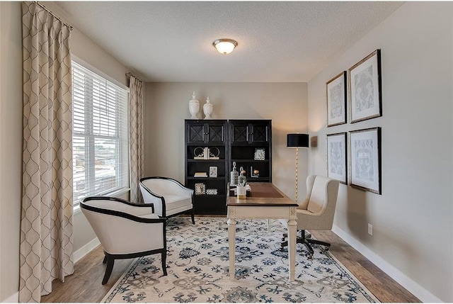 home office with hardwood / wood-style floors, a healthy amount of sunlight, and a textured ceiling