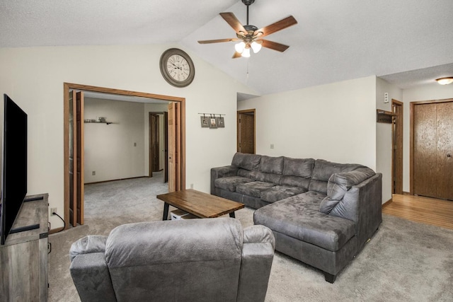 carpeted living room featuring ceiling fan and vaulted ceiling