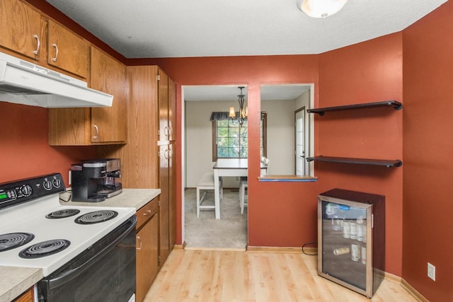 kitchen featuring pendant lighting, light wood-type flooring, an inviting chandelier, and white range with electric stovetop