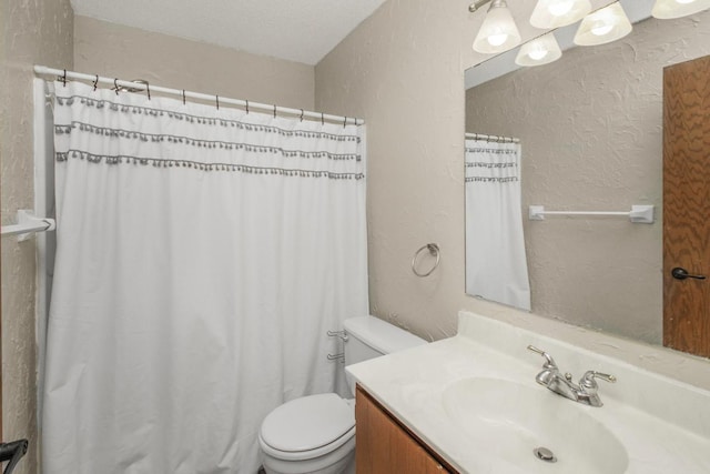 bathroom featuring vanity, a textured ceiling, and toilet