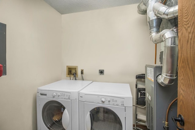 clothes washing area featuring a textured ceiling and washer and clothes dryer