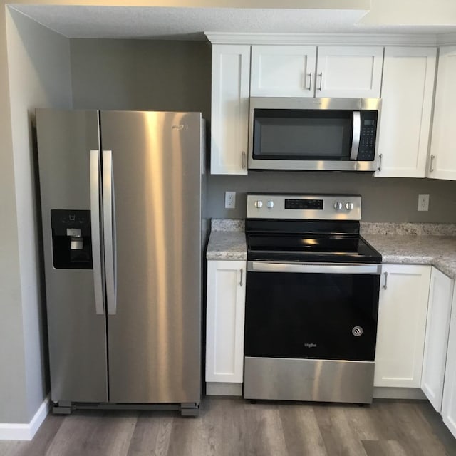 kitchen featuring white cabinetry, stainless steel appliances, and dark wood-type flooring