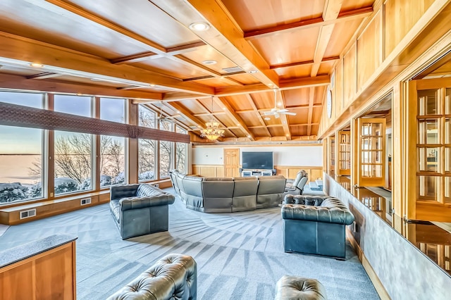 interior space featuring beamed ceiling and ceiling fan with notable chandelier