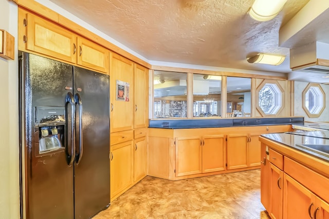 kitchen featuring a textured ceiling and black fridge