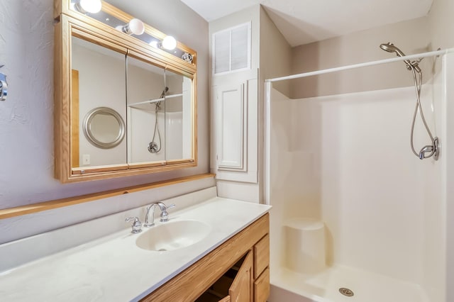 bathroom with walk in shower and vanity