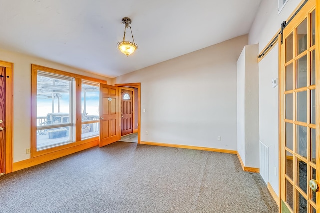 spare room featuring carpet flooring and a barn door