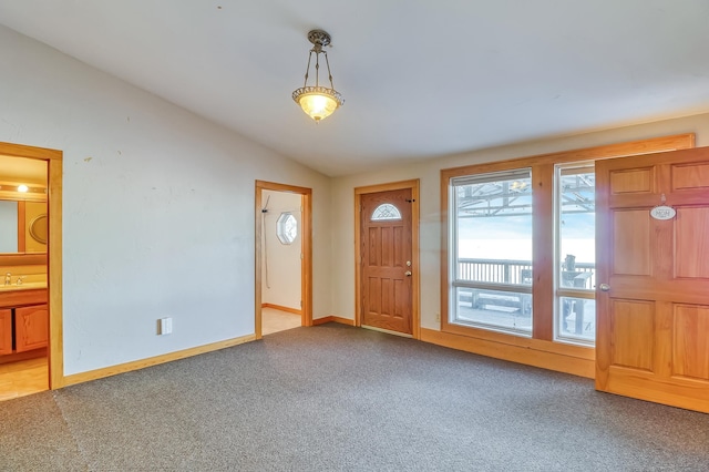 carpeted entrance foyer with vaulted ceiling