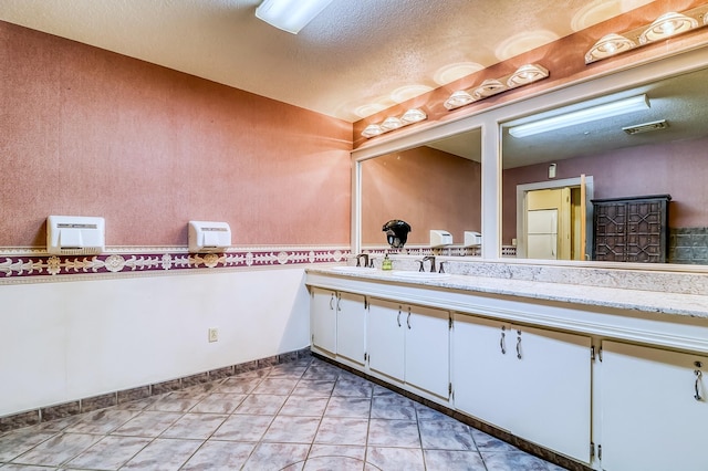 bathroom featuring vanity, tile patterned floors, and a textured ceiling