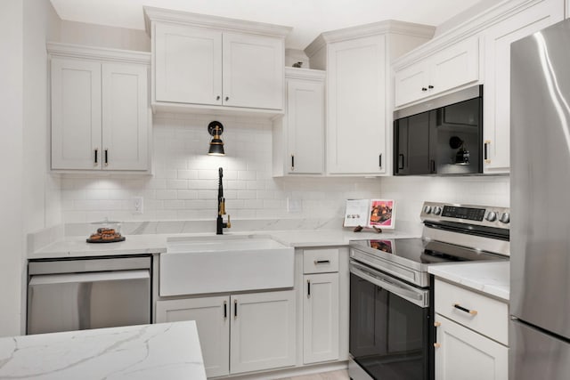 kitchen featuring decorative backsplash, white cabinetry, sink, and stainless steel appliances