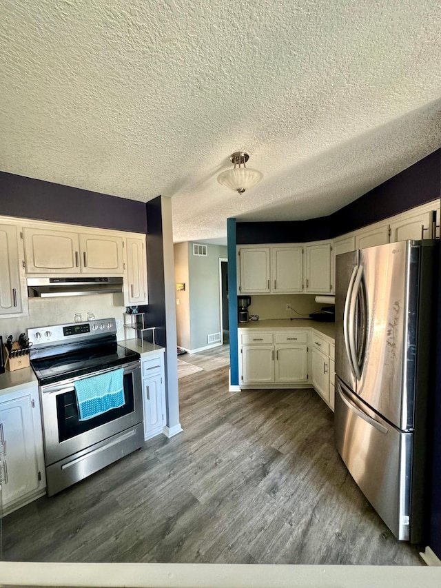 kitchen with a textured ceiling, white cabinetry, light wood-type flooring, and stainless steel appliances