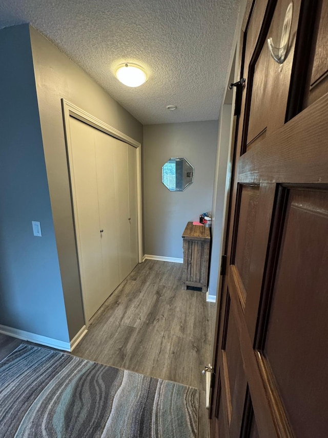 hall featuring a textured ceiling and hardwood / wood-style flooring