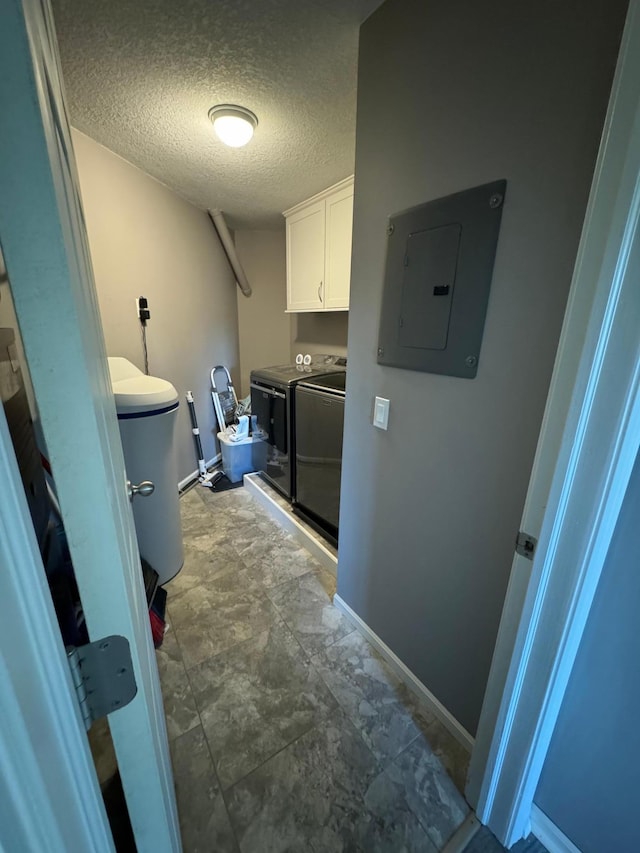 clothes washing area with cabinets, independent washer and dryer, a textured ceiling, and electric panel