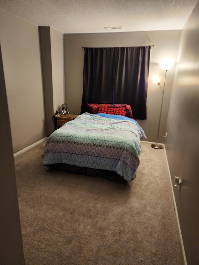 bedroom with carpet and a textured ceiling