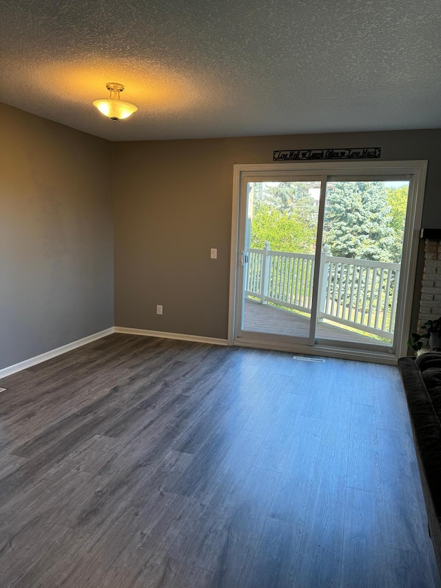 empty room with hardwood / wood-style floors and a textured ceiling