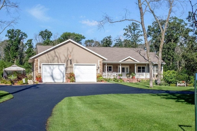 view of front facade featuring a front yard, a porch, and a garage