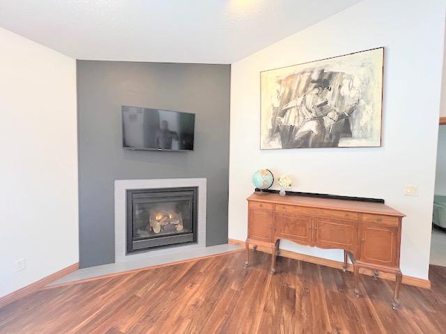 living room with wood-type flooring and lofted ceiling