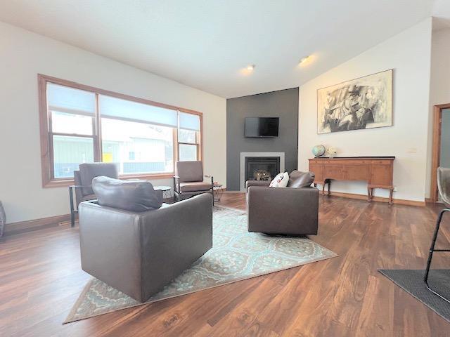 living room featuring wood-type flooring and vaulted ceiling