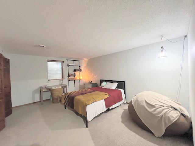 carpeted bedroom with a textured ceiling