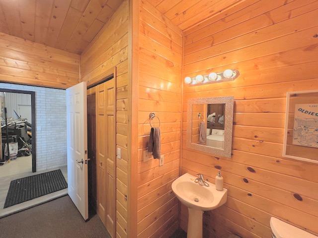 bathroom with wooden ceiling and wooden walls