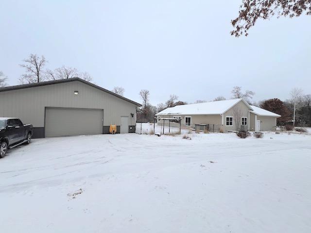 view of snow covered exterior with a garage and an outdoor structure