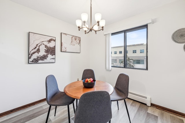 dining area featuring baseboard heating, hardwood / wood-style floors, and a chandelier