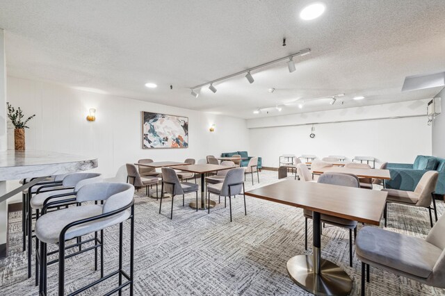 dining room featuring a textured ceiling and rail lighting