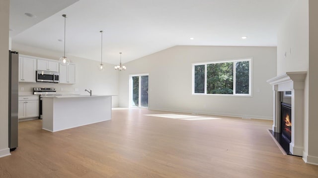 unfurnished living room featuring vaulted ceiling, an inviting chandelier, light hardwood / wood-style flooring, and sink