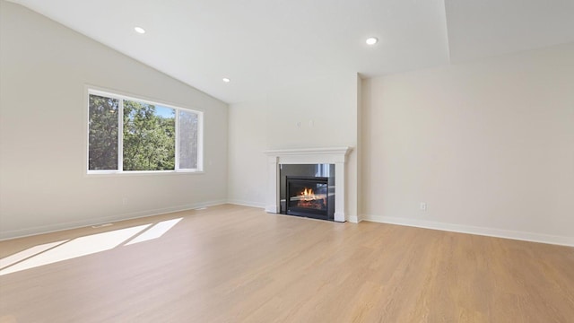 unfurnished living room with lofted ceiling and light hardwood / wood-style flooring