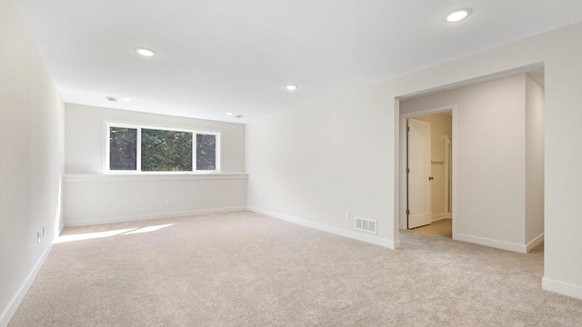 spare room featuring light colored carpet