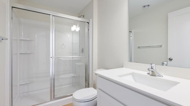 bathroom with walk in shower, vanity, and toilet