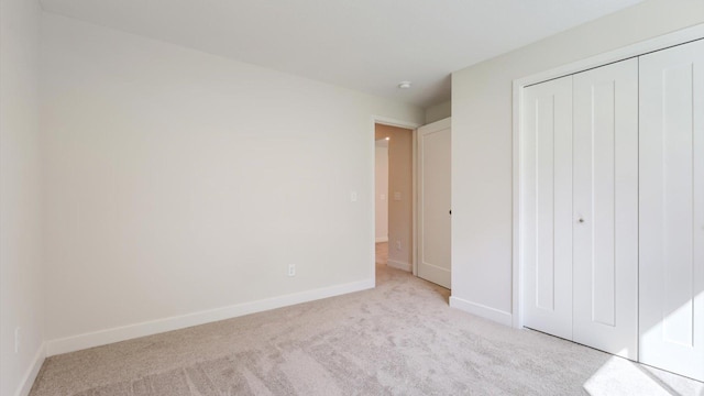 unfurnished bedroom with light carpet and a closet