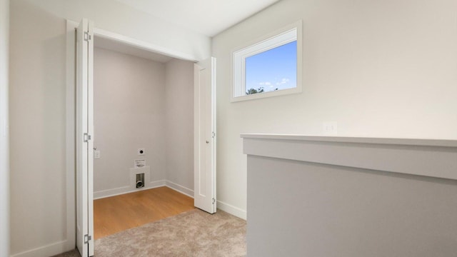 washroom with hookup for an electric dryer and light wood-type flooring