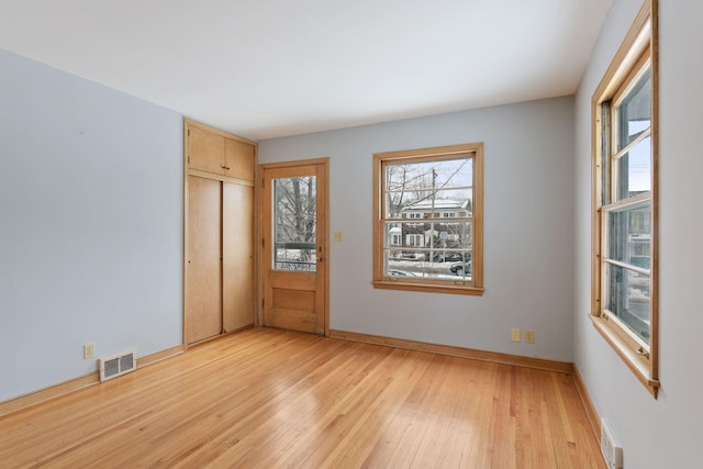 unfurnished bedroom featuring light wood-type flooring and a closet