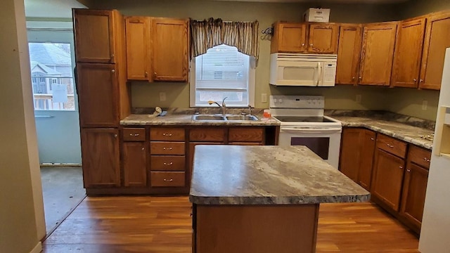 kitchen featuring wood-type flooring, white appliances, a wealth of natural light, and sink