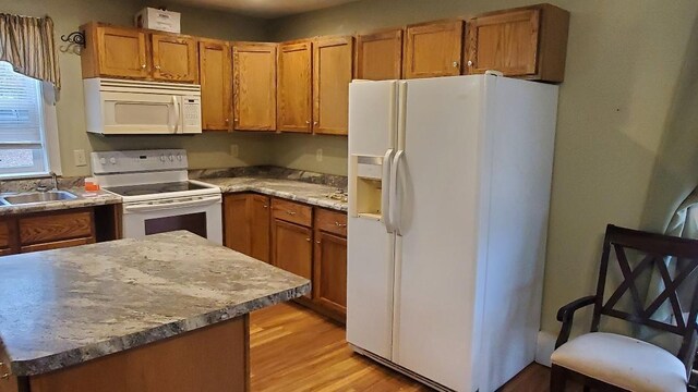 kitchen featuring white appliances, sink, and light hardwood / wood-style flooring