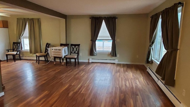 sitting room with baseboard heating and dark wood-type flooring