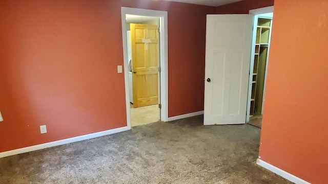 unfurnished bedroom with concrete floors, a spacious closet, and a closet