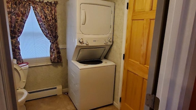 laundry room featuring stacked washer and clothes dryer and a baseboard heating unit