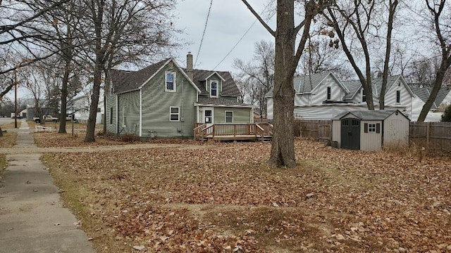 view of front of property featuring a deck and a storage shed