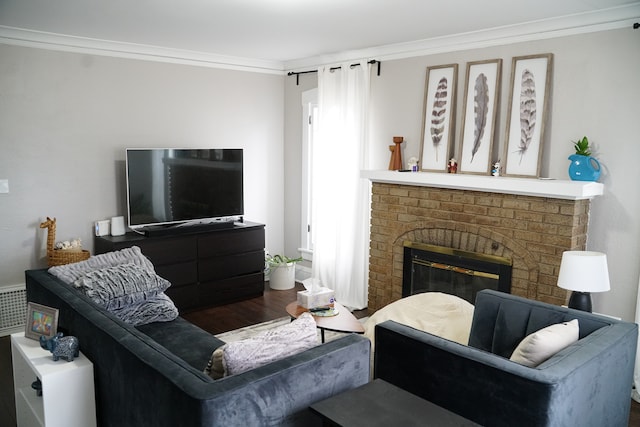 living room with hardwood / wood-style floors, ornamental molding, and a fireplace