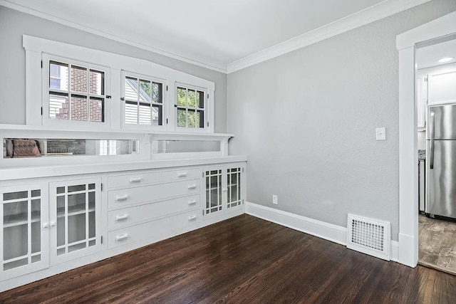 spare room featuring crown molding and dark hardwood / wood-style floors