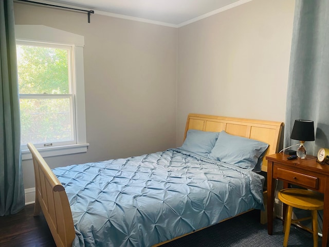 bedroom with dark wood-type flooring, crown molding, and multiple windows