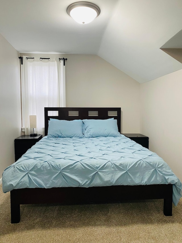 bedroom with carpet floors and lofted ceiling