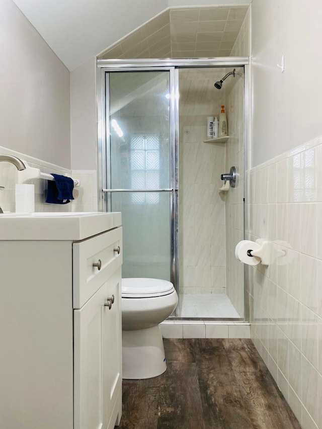 bathroom featuring walk in shower, sink, tile walls, hardwood / wood-style floors, and toilet