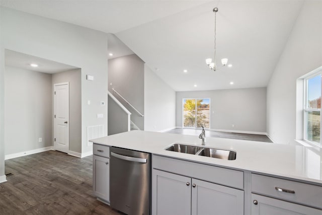 kitchen featuring stainless steel dishwasher, sink, gray cabinets, dark hardwood / wood-style floors, and lofted ceiling